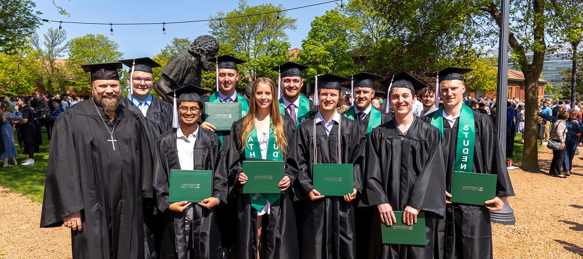 Group of grads by Divine Servant Statue on WLC Quad